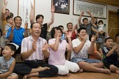 거실에 모여 앉아 박수를 치며 좋아하고 있는 박성현선수의 가족5사진(00005)