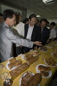 전시된 음식들을 가리키며 설명하고 있는 관계자와 듣고 있는 시장님과 관련인사들3사진(00009)