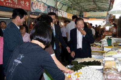 시장에서 팔고 있는 떡을 먹고 계신 시장님