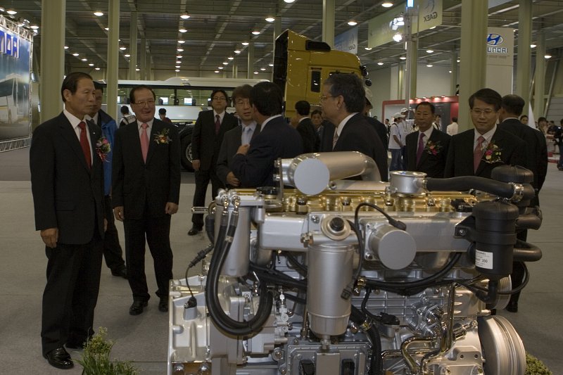 자동차 EXPO 전시회에 전시된 자동차내부기계를 보고 있는 시장님과 관련인사들