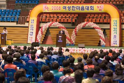 무대 위에서 말씀하고 계신 관련인사와 자리에 앉아 듣고 계신 사람들