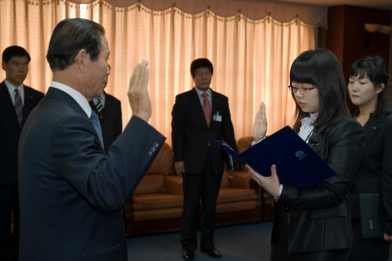 앞에 나와 선서문을 읽으며 선서를 하고 있는 임원과 선서를 하고 있는 시장님