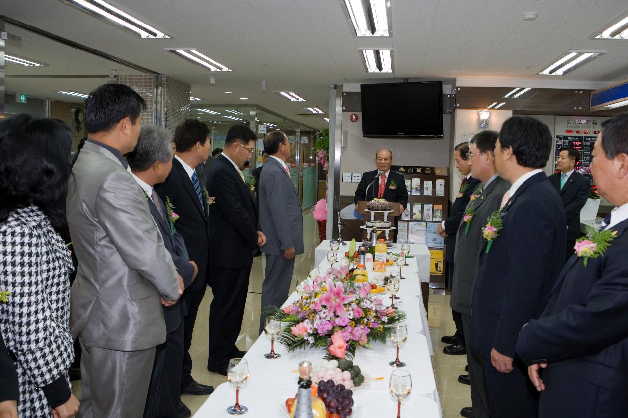 앞에서 말씀하고 계시는 대표님과 테이블 앞에 서서 듣고 계신 관련인사들