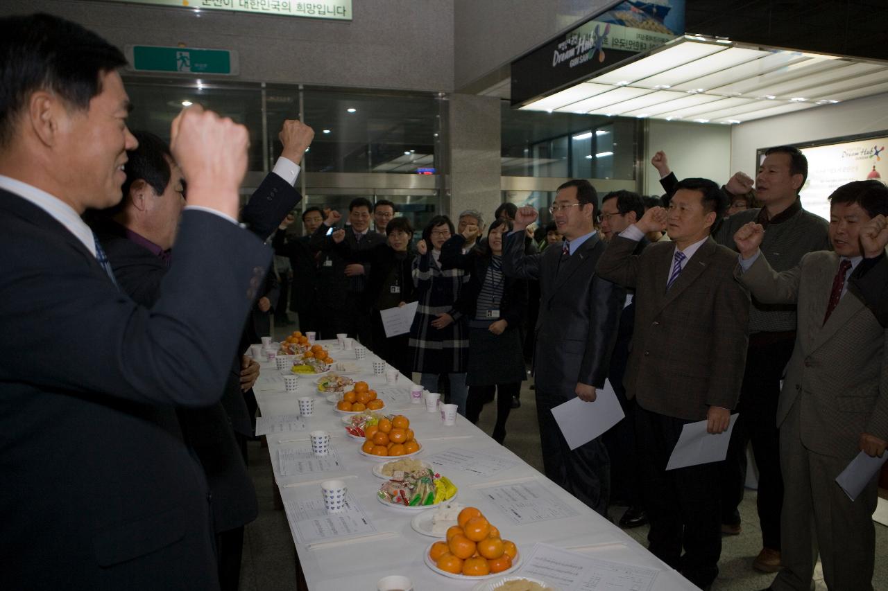 테이블을 둘러 서서 함께 화이팅을 외치고 있는 관련인사들