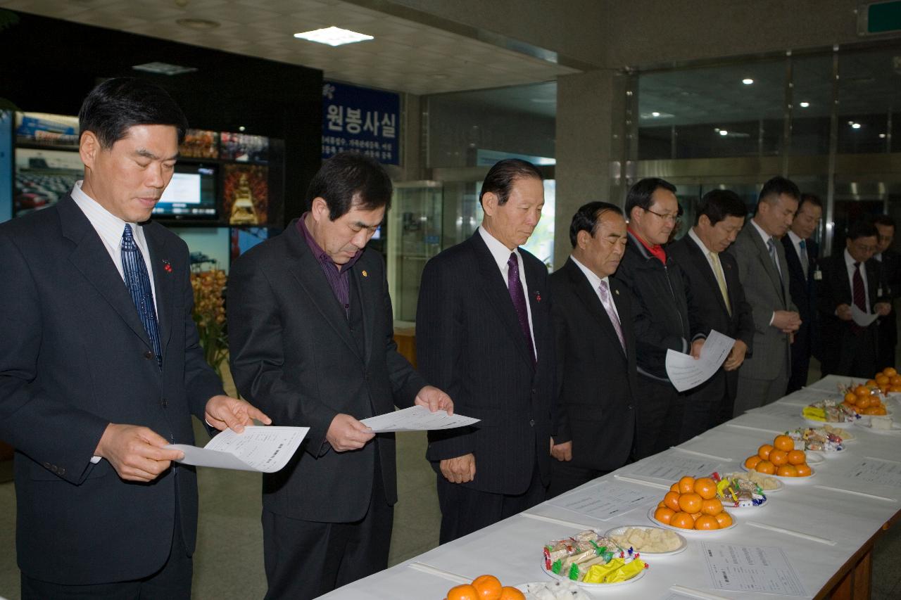 테이블 앞에 서서 자료를 들고 묵념하고 계신 시장님과 관련인사들