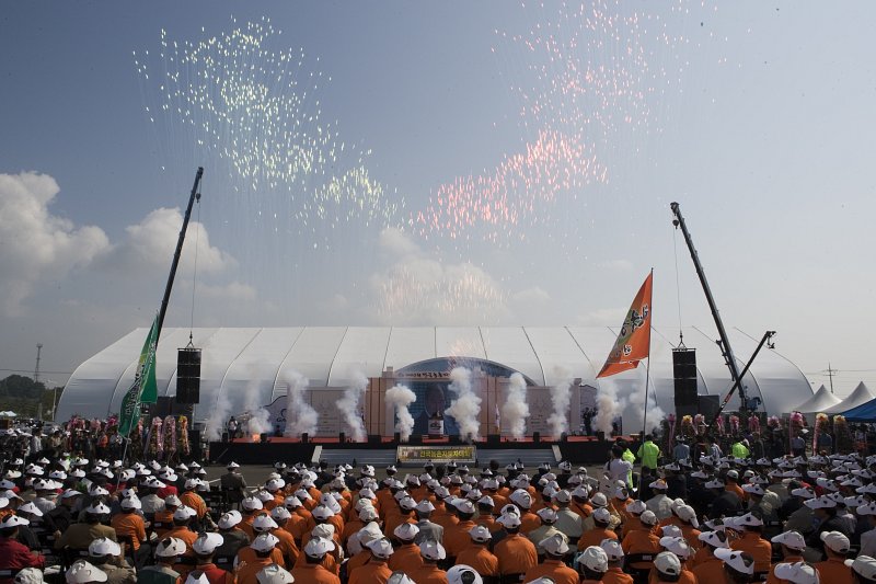 전국농촌지도자대회를 축하하며 무대에서 연기가 올라오고 하늘에 색색의 가루들이 날리고 있는 모습