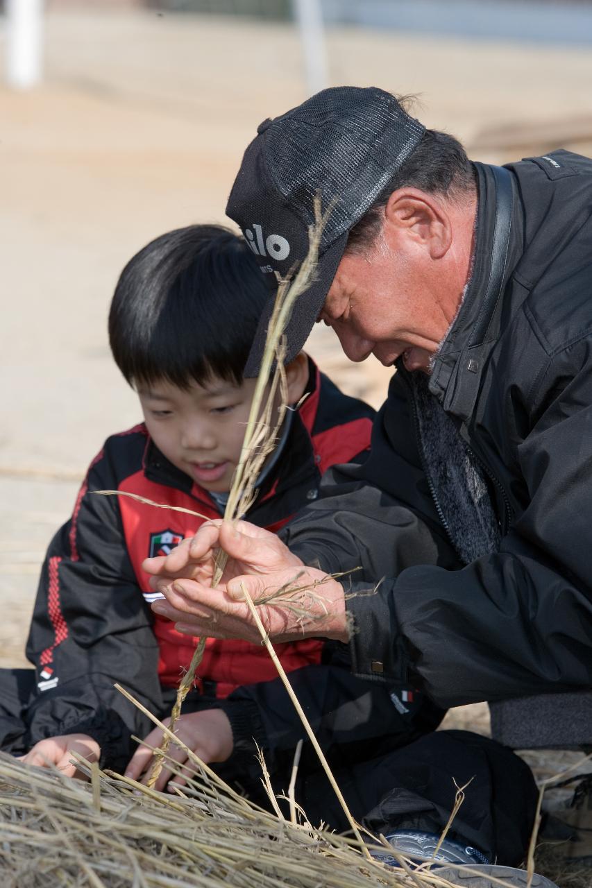 짚꼬는것을 알려주는 아저씨와 열심히 따라하는 아이2