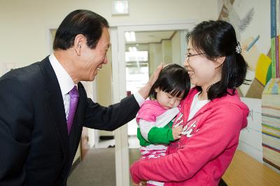 엄마품에서 자는 아이의 머리를 쓰다듬는 시장님