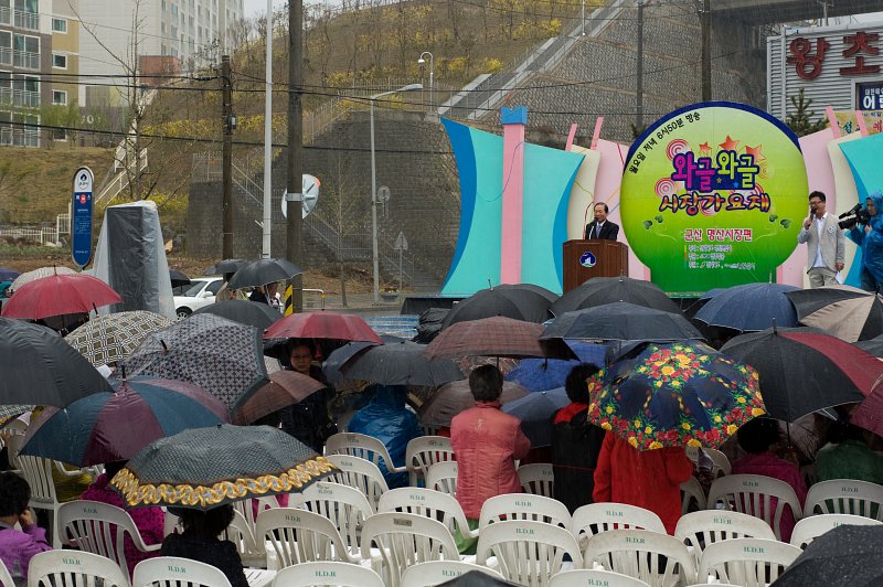 연설 중이신 시장님.비가와도 우산을 쓰며 모여있는 관객들3