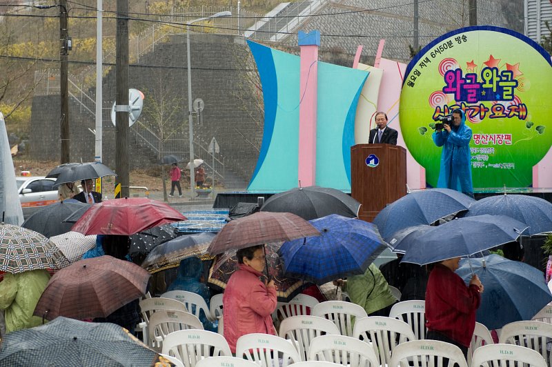 연설 중이신 시장님.비가와도 우산을 쓰며 모여있는 관객들4