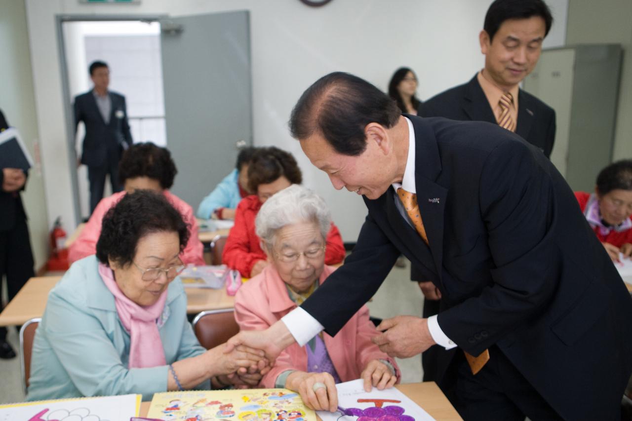 할머니와 악수를 하시는 시장님의 모습