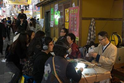 사주를 보는 여성시민들과 음악을 듣고있는 남성시민들