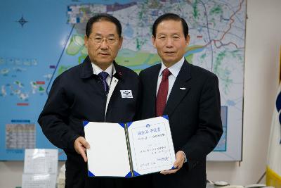 대창상사 이웃돕기 성금전달 증서를 함께 펼쳐들고 있는 시장님과 대표님