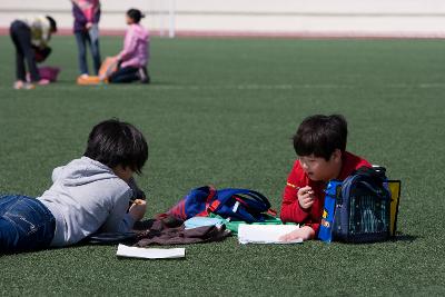 잔디밭에 앉아서 글을 쓰고있는 아이들1