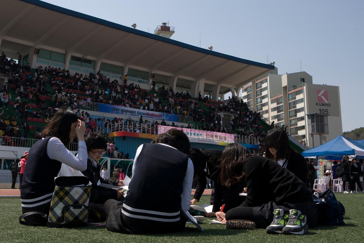 잔디밭에 앉아서 글을 쓰고있는 여고생들1