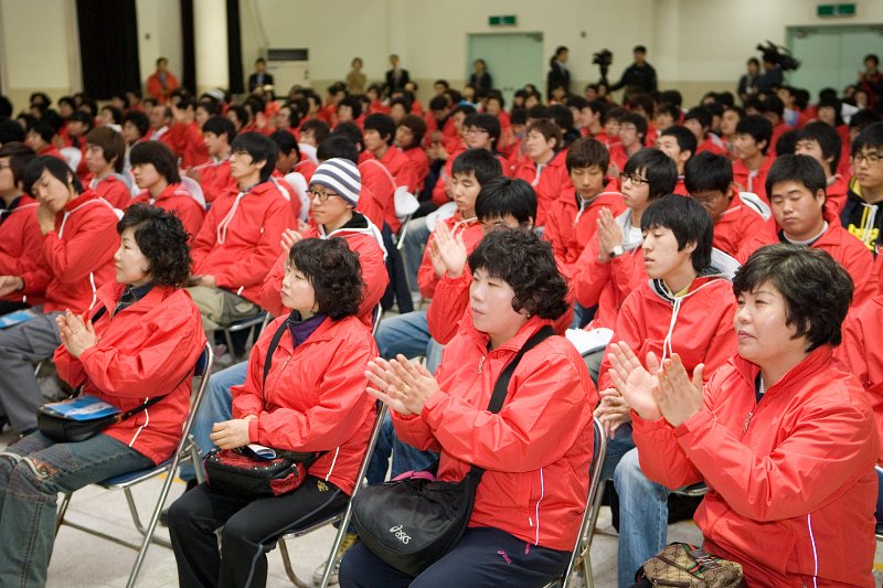 박수를 치는 빨간옷을 입은 자원봉사자들