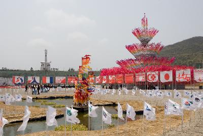 가운데 연못 주위로 세계 나라들 국기와 우리나라 각 지역을 대표하는 깃발들 뒤로 보이는 깃발탑