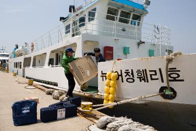 배에서 투표함을 내리는 직원들의 모습3