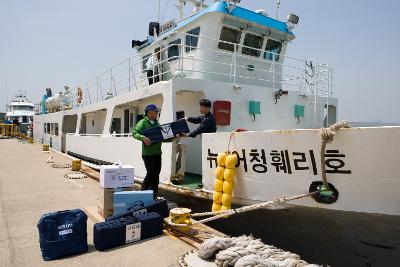 배에서 투표함을 내리는 직원들의 모습1