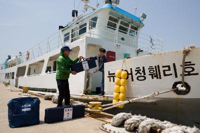 배에서 투표함을 내리는 직원들의 모습4