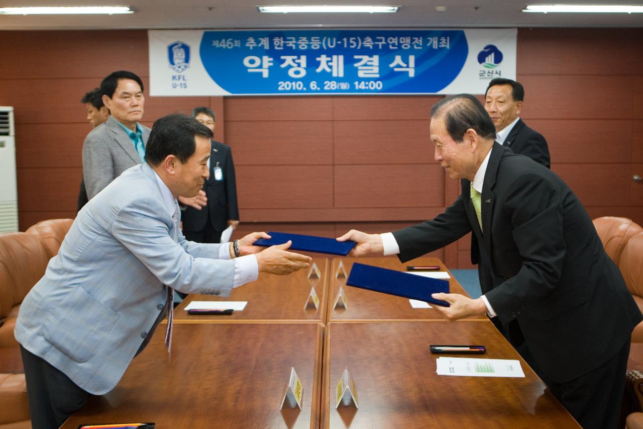 중등축구연맹 개최협약 체결문을 교환하는 모습