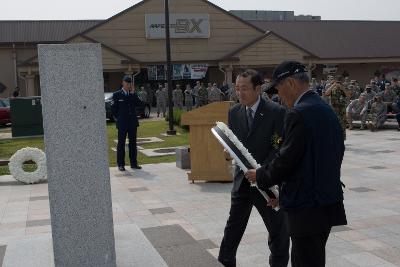 국화꽃이 달린 원판을 묘비에 올러놓는 부시장님과 미공군대표1