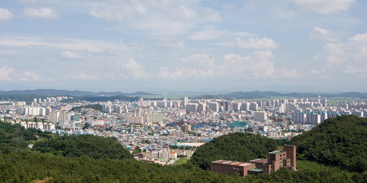 앞에는 산이 보이고 뒤에 건물들이 늘어서있는 시가지 전경2