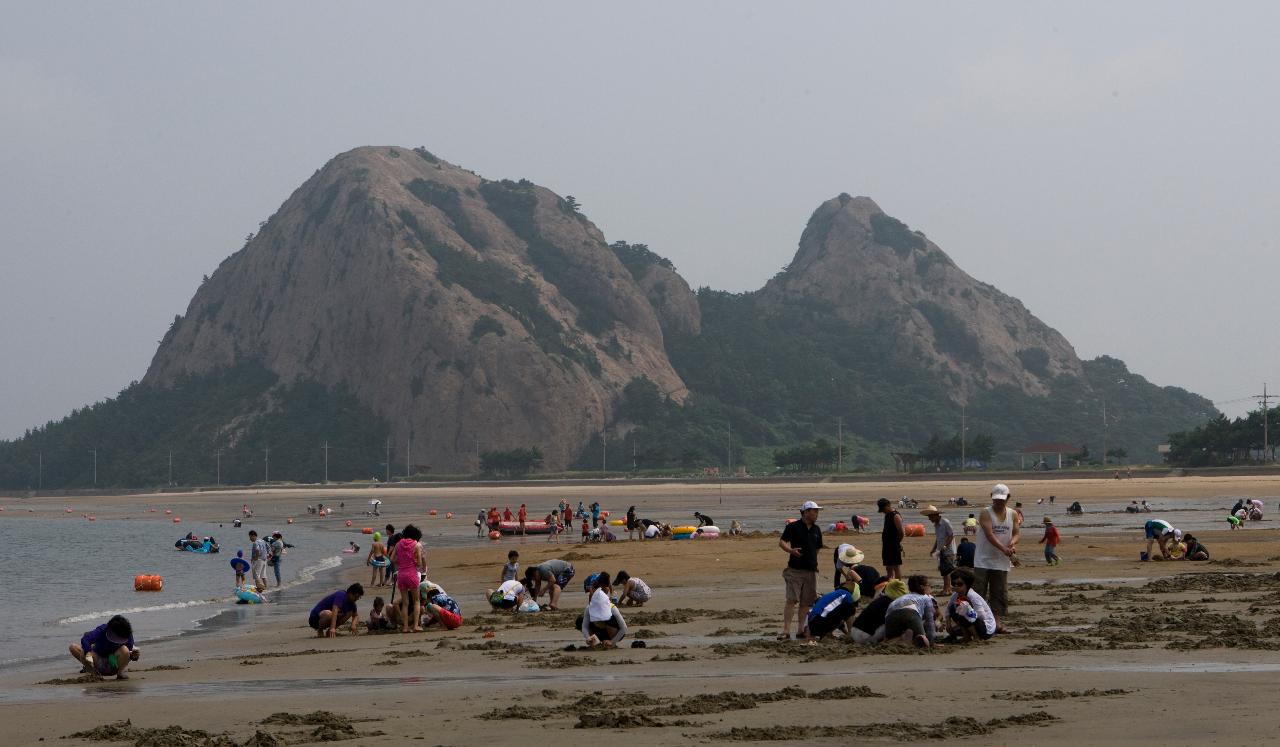 사람들이 놀고있는 해수욕장 뒤로 망주봉이 보이는 전경3