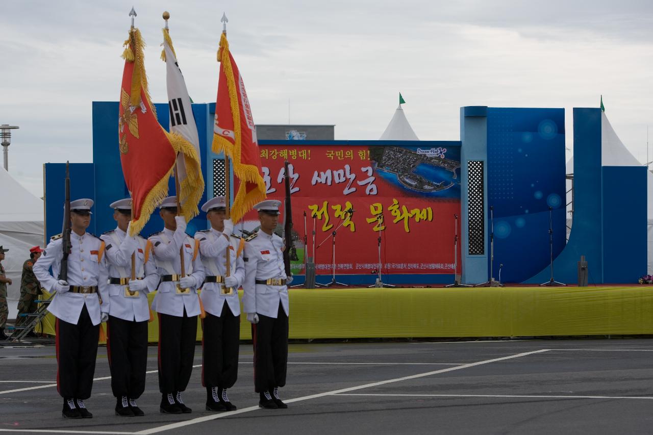 태극기와 해병대 깃발과 총을 들고 일렬로 서있는 학군단의 모습