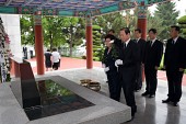 묘비에 국화꽃일 들고계신 시장님부부와 뒤에 일렬로 서있는 관계자들사진(00006)