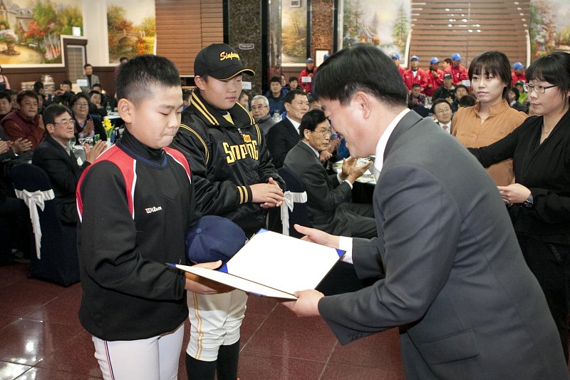 어린 야구부 학생에게 상장이 수여되고 있다.