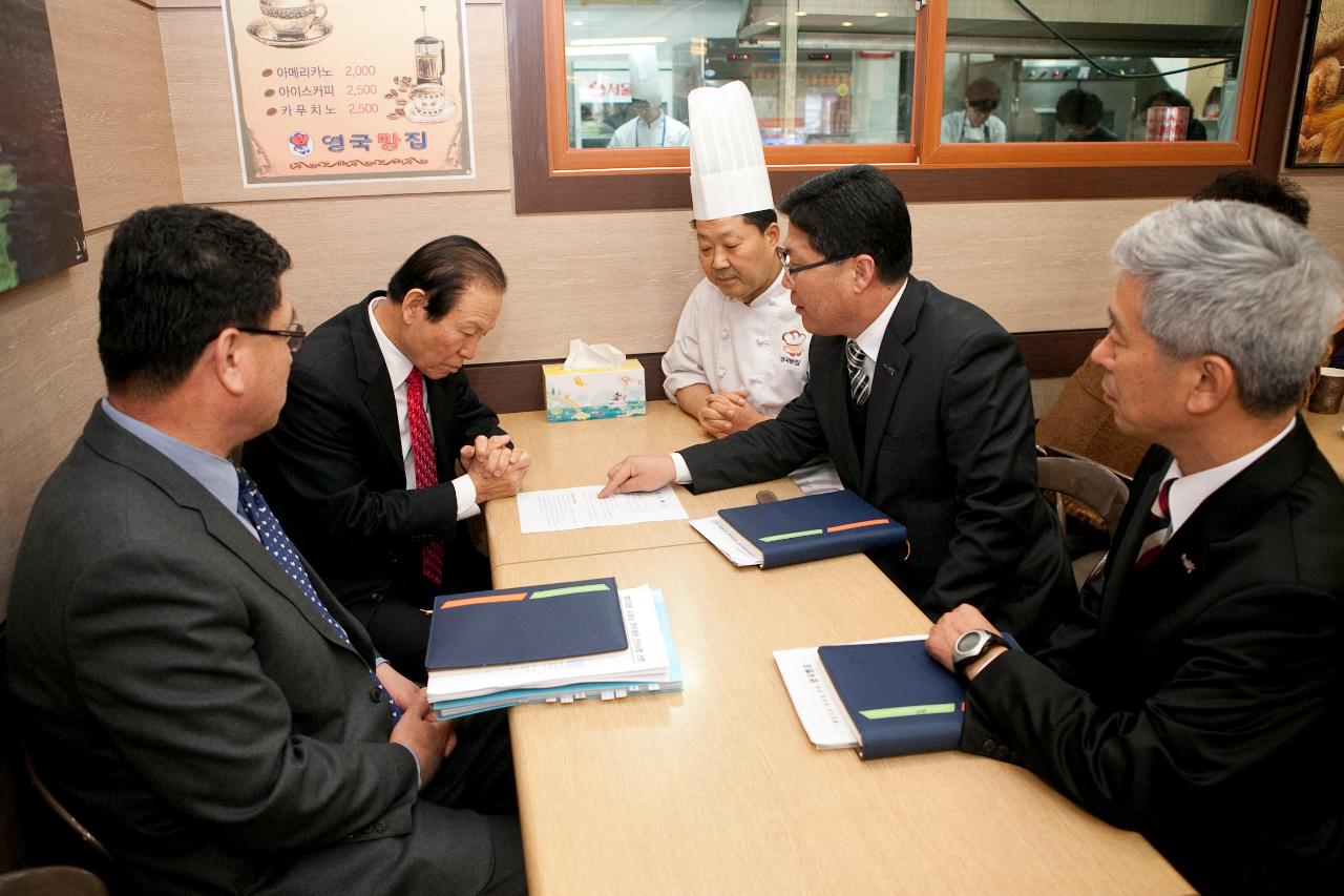 영국빵집 관계자에게 대략적인 설명을 듣고있는 시장님.