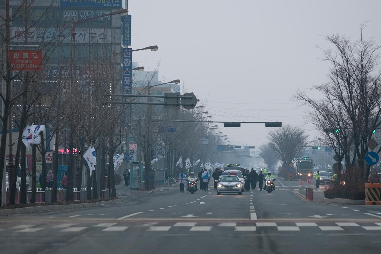 경찰의 에스코트를 받으며 성화가 도로로 들어오고있다.