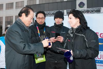 시장님이 성화봉송 주자에게 컵을 선물하고있다.