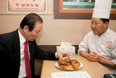 시장님이 빵을 맛 보기전 외관을 보고있다.