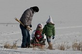한겨울  네 가족이 아버지가 끌어주는 눈썰매를 타고있다.사진(00001)